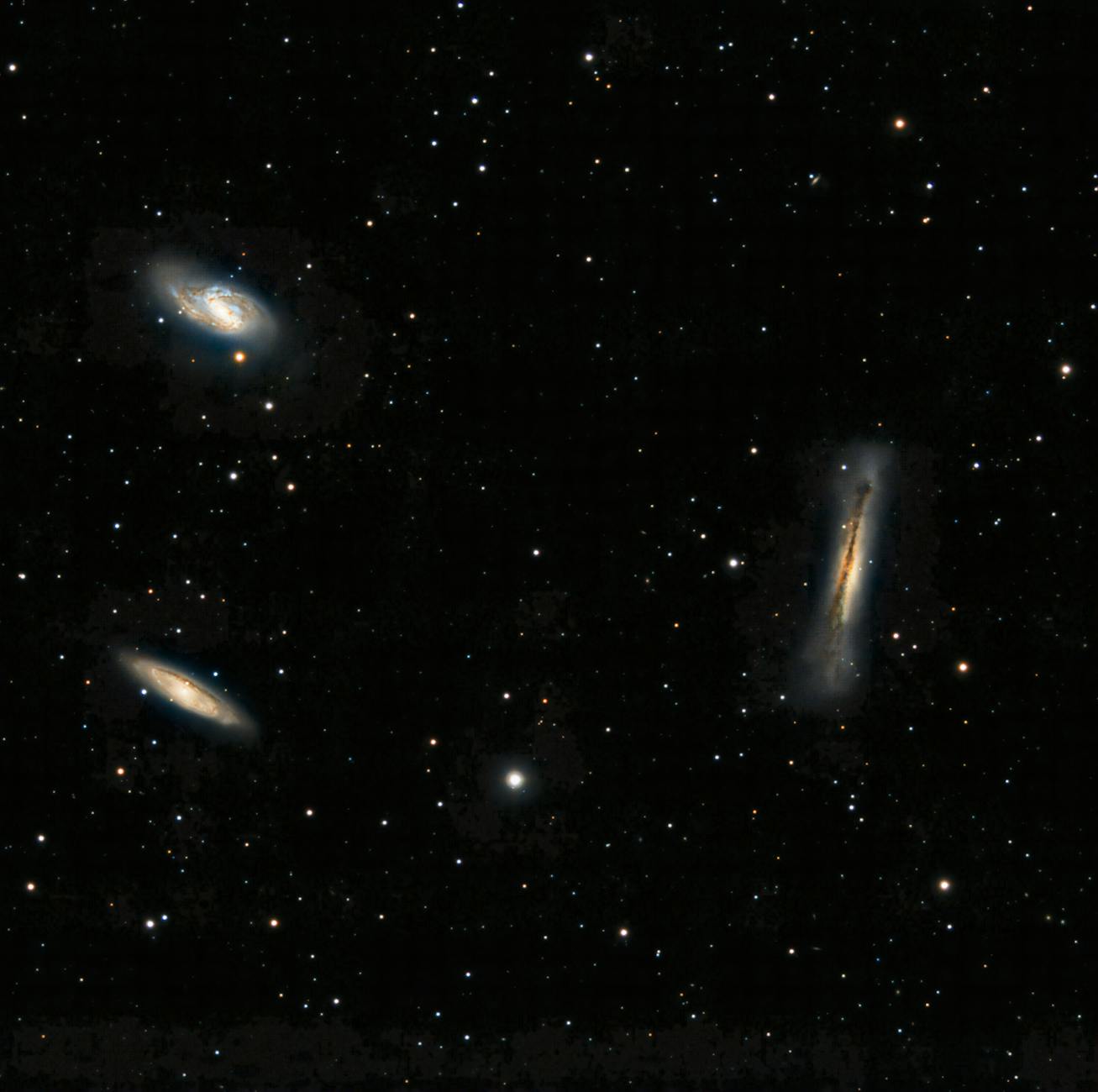 Capture of three distinct galaxies amidst countless stars in the vast cosmos.